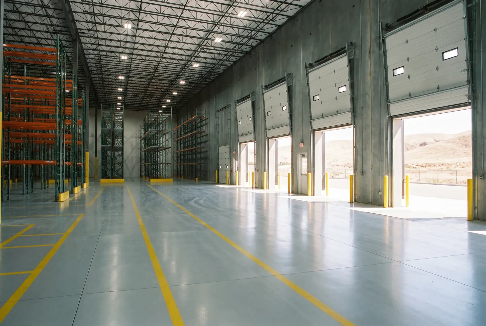 Warehouse floor coated with gray epoxy and yellow safety lanes